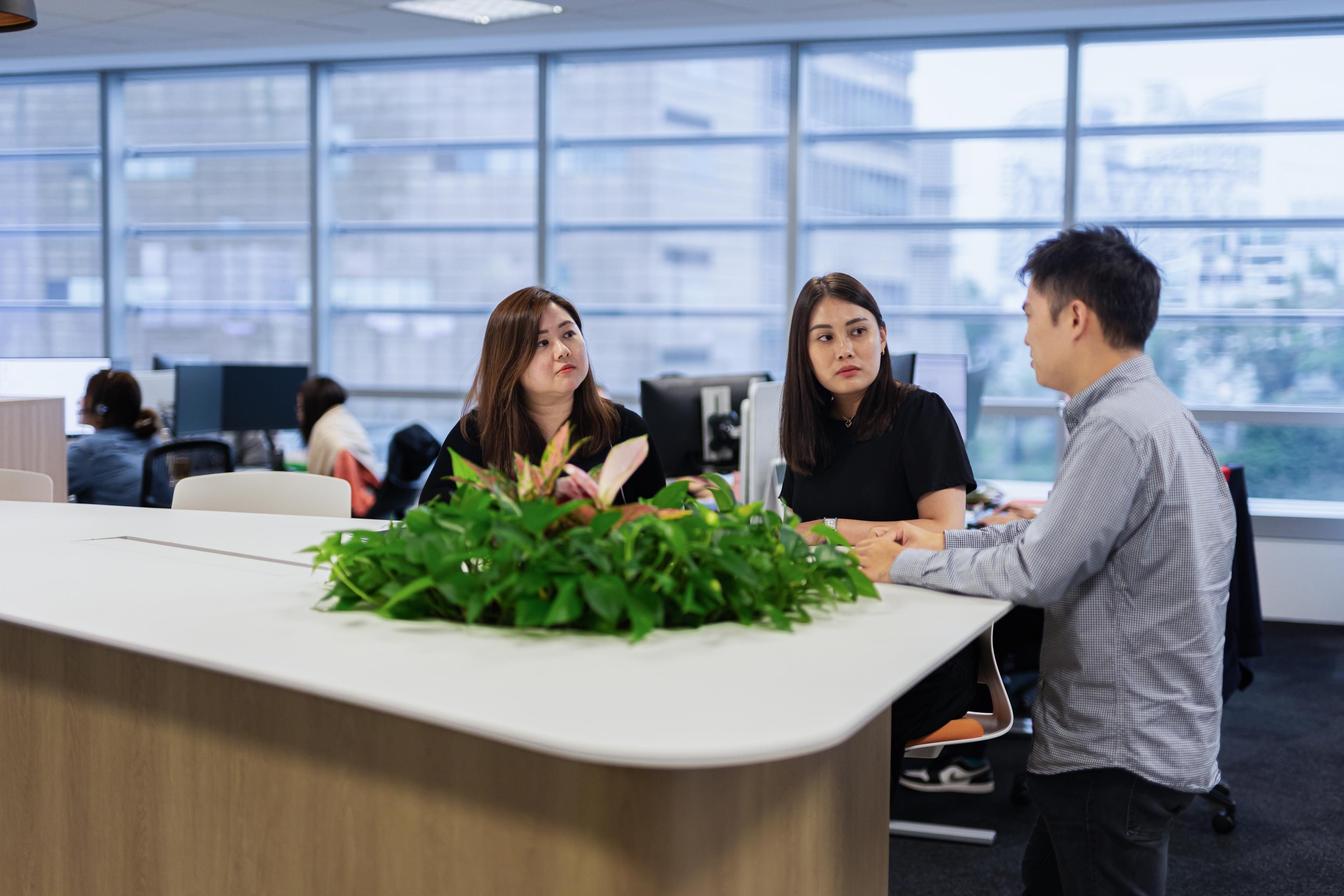 Three Fusion Worldwide employees talking in the APAC headquarters