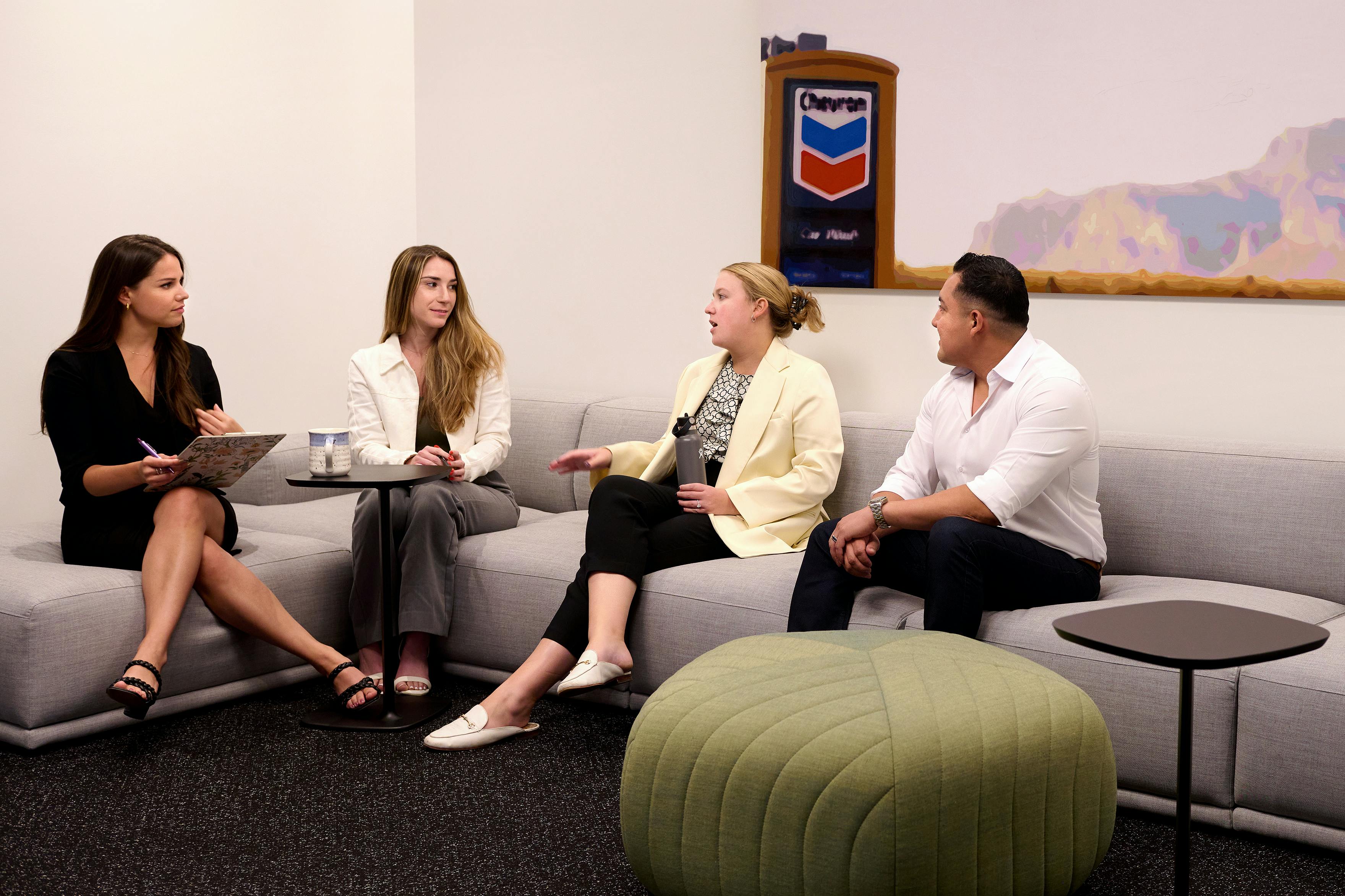 Employees gather on a couch for an informal meeting