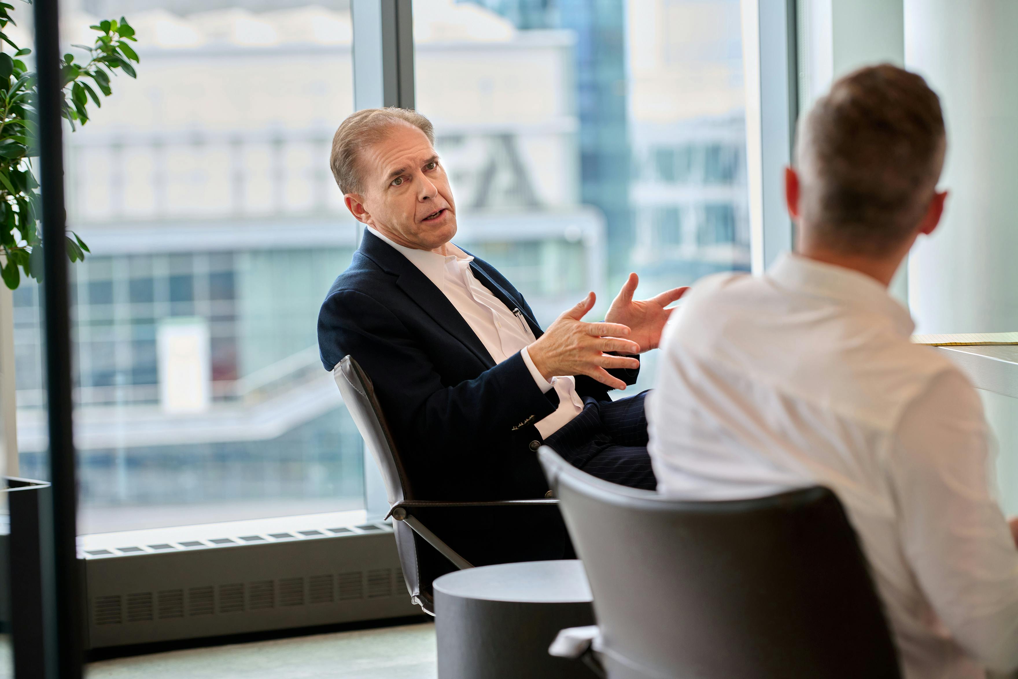 Fusion Worldwide COO Paul speaks to a coworker in a conference room